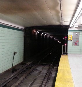 He looked the length of the platform and saw the neon pink of her backpack fade into the darkness of the tunnel as she climbed down the ladder at the far end. 